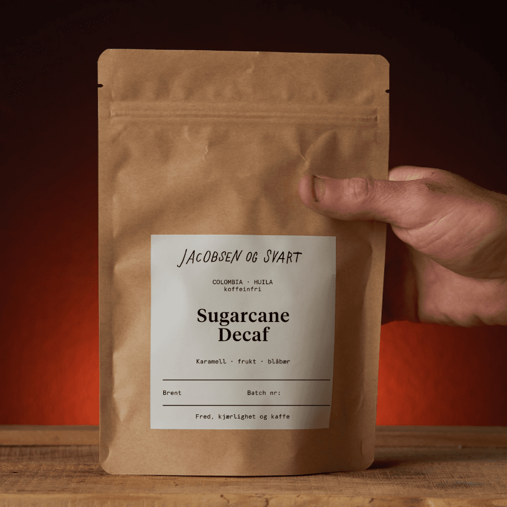 Brun papirpose med kaffe som blir holdt i hånden